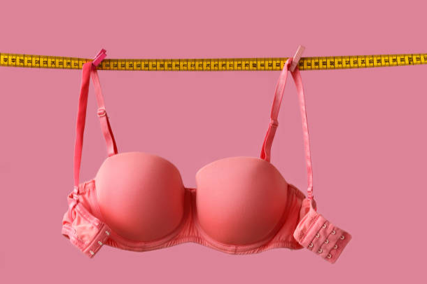 A picture of a bra hanging on measuring tape